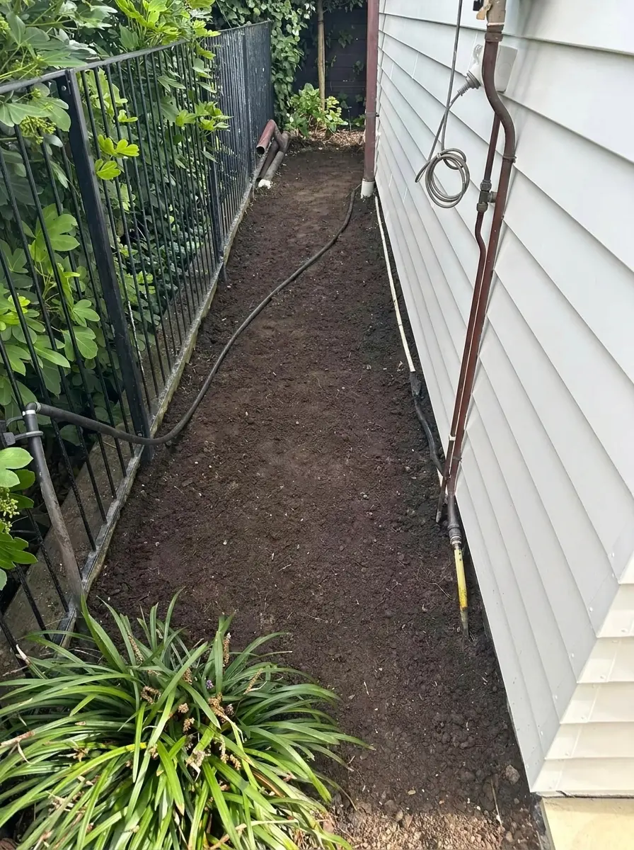 After stump removal: narrow side path strip completely cleared of stumps with levelled soil